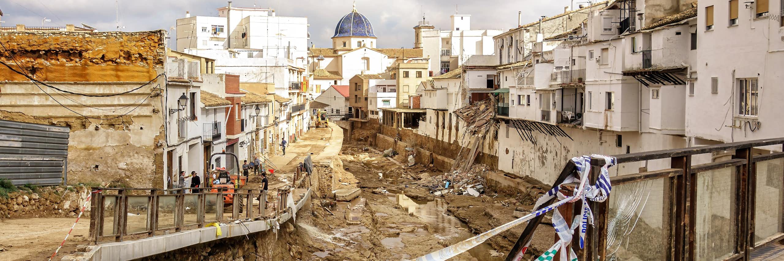 Una rambla cubierta de escombros a su paso por un pueblo