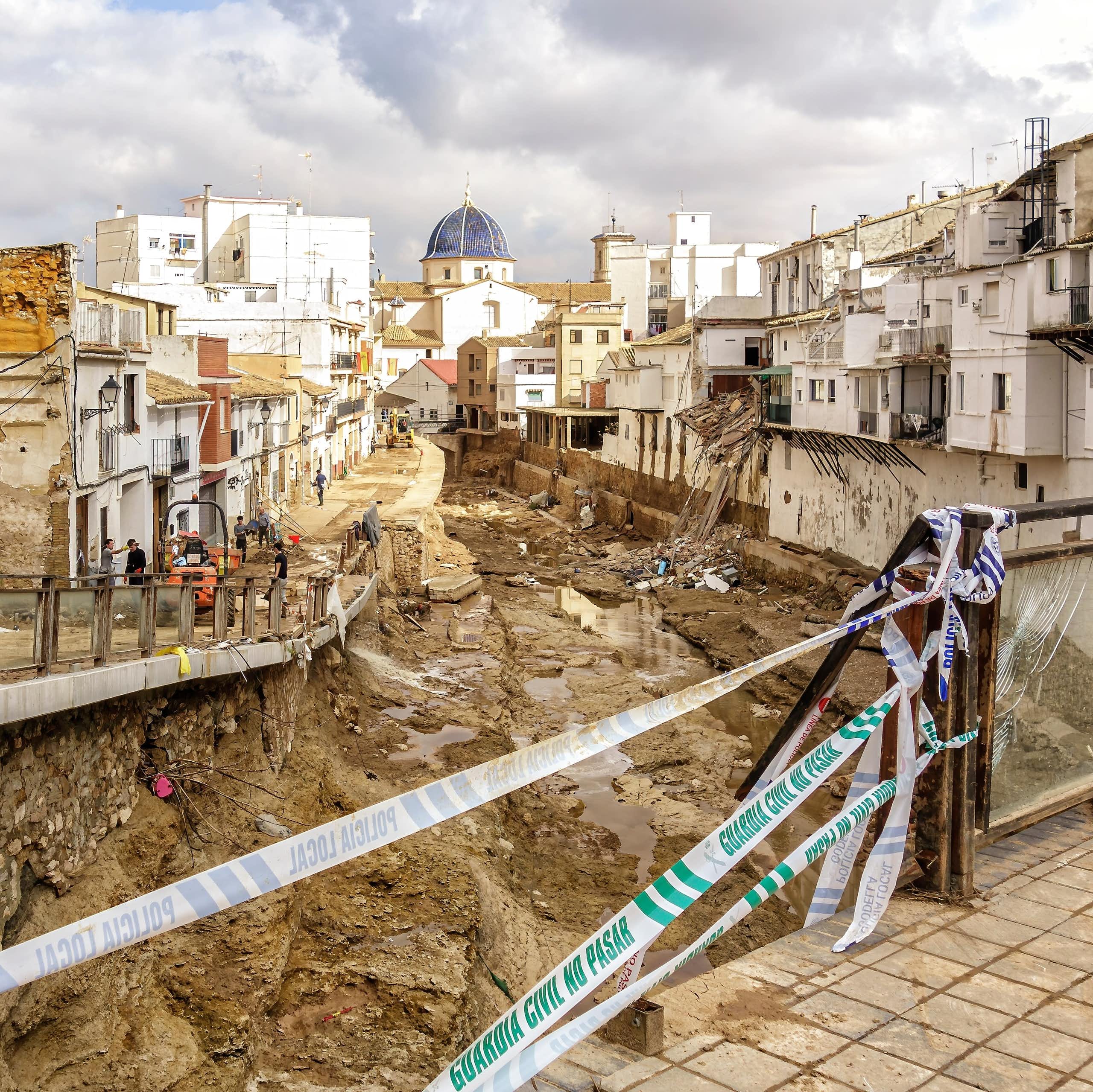 Una rambla cubierta de escombros a su paso por un pueblo