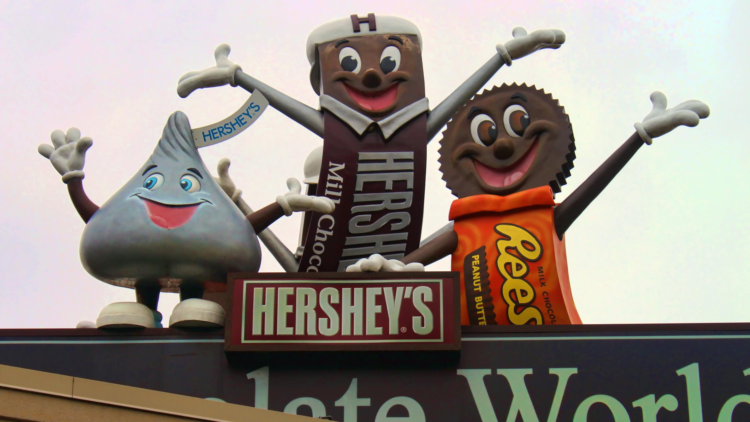 Colorful statues of iconic candy brands on roof of building