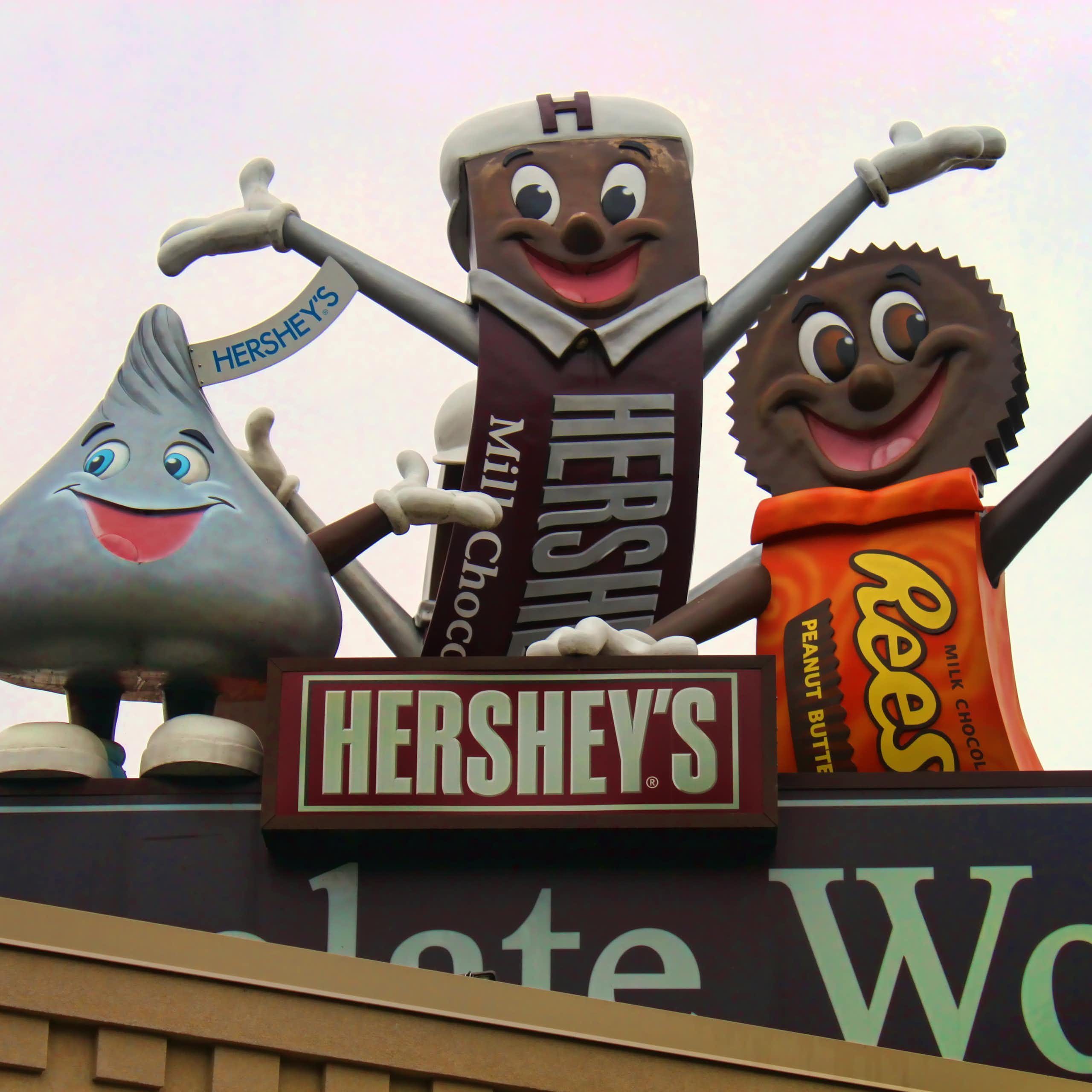 Colorful statues of iconic candy brands on roof of building