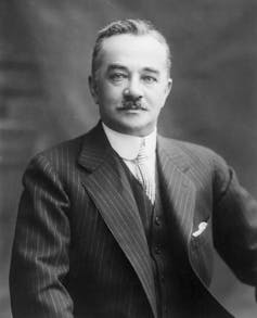 Black and white portrait of man with mustache wearing three-piece suit