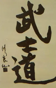 Large Black characters in Asian script on a gray-yellow piece of paper.