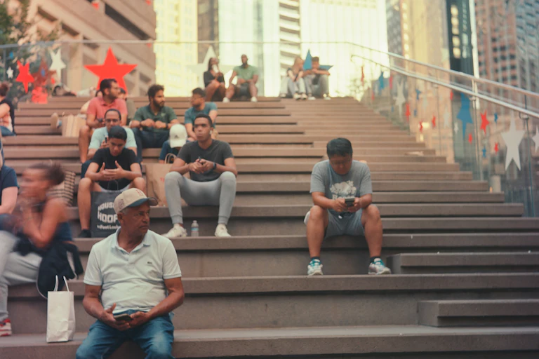 People sitting on large concrete steps in an urban setting