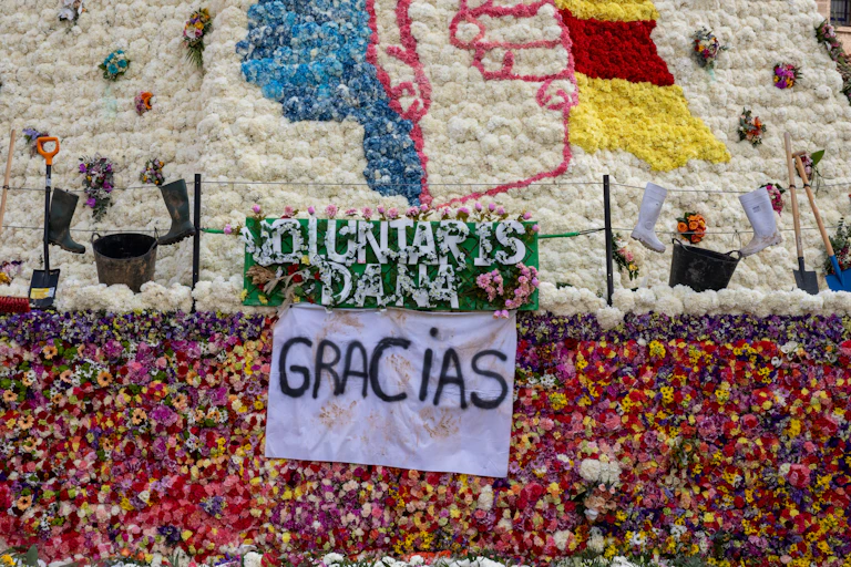 Detalle de un manto floral donde puede leerse "Voluntaris DANA, Gracias"