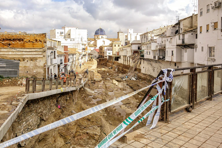 A riverbed filled with rubble passes through a town.