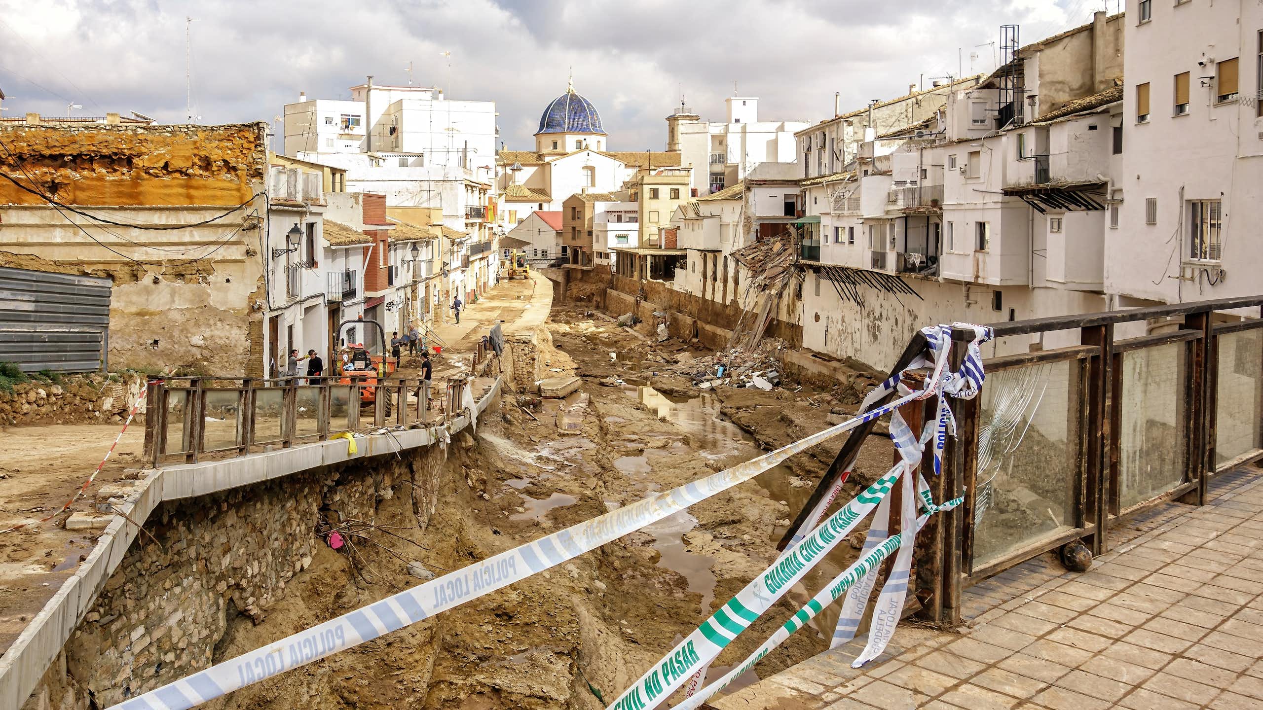 A riverbed filled with rubble passes through a town.