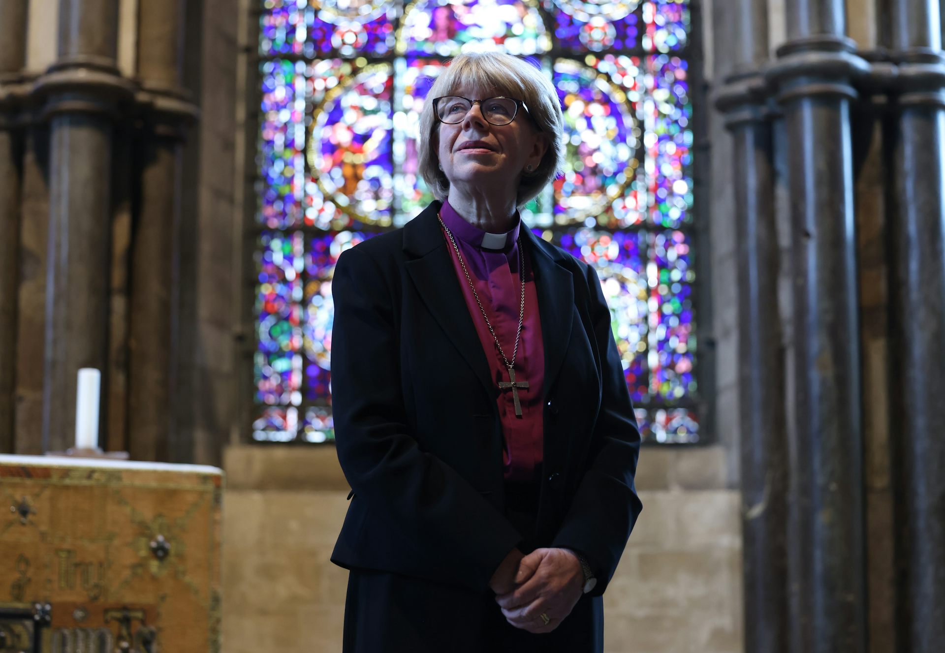 archbishop of canterbury sarah mullally standing in front of a stained glass window.