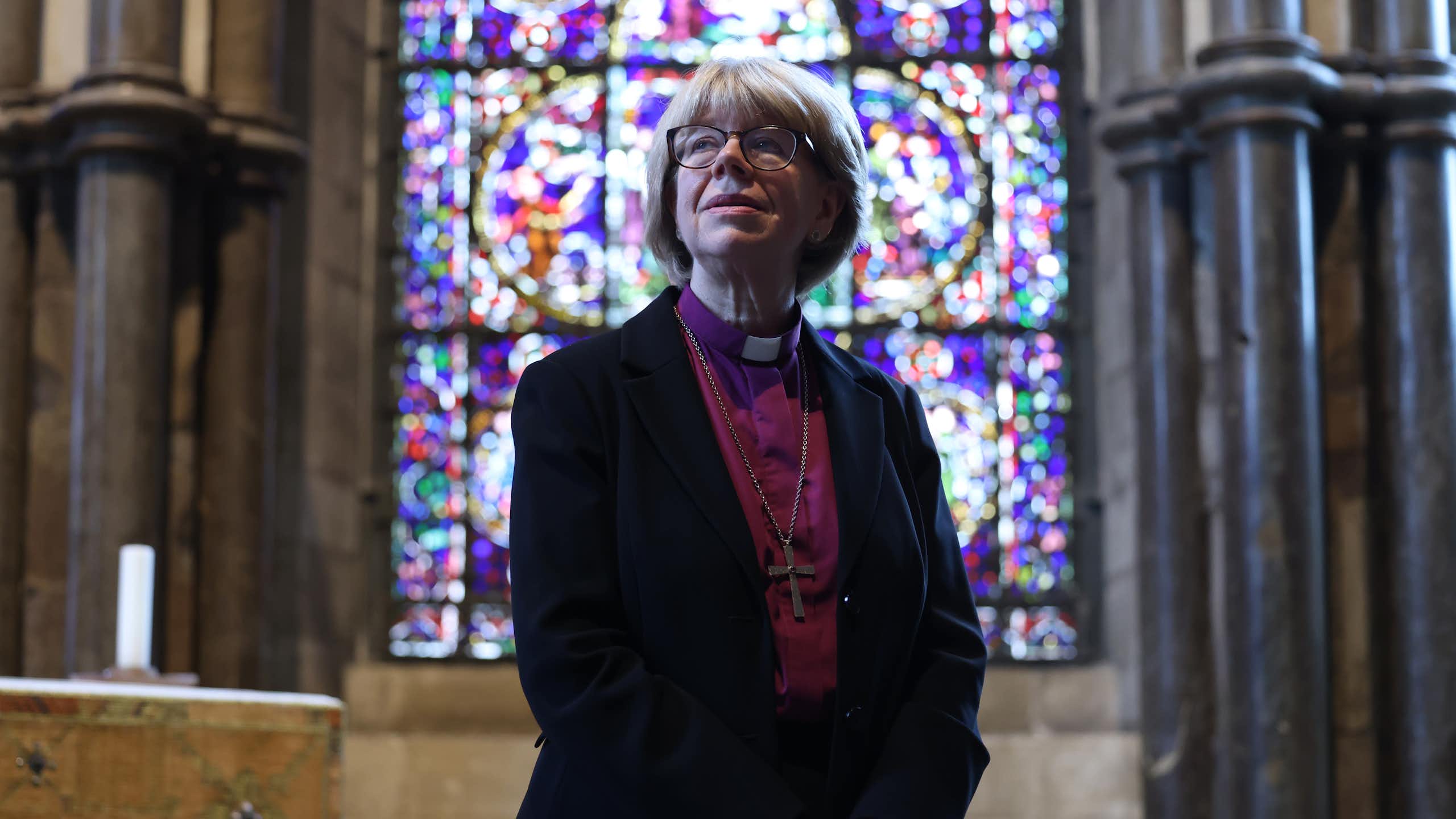 archbishop of canterbury sarah mullally standing in front of a stained glass window.