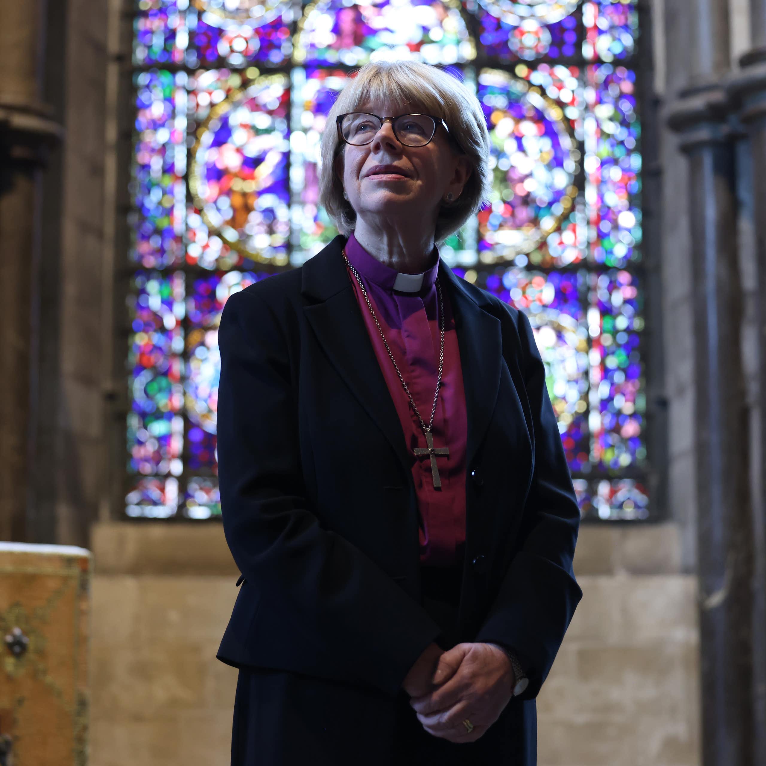 archbishop of canterbury sarah mullally standing in front of a stained glass window.