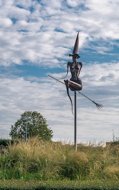 Witch memorials are quietly spreading throughout Europe 1 A statue of a naked witch on a broomstick with a pointy hat.