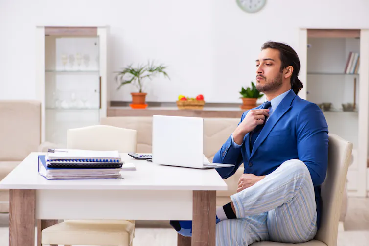 homeworking man wearing a suit on his top half and pyjamas on his bottom half.