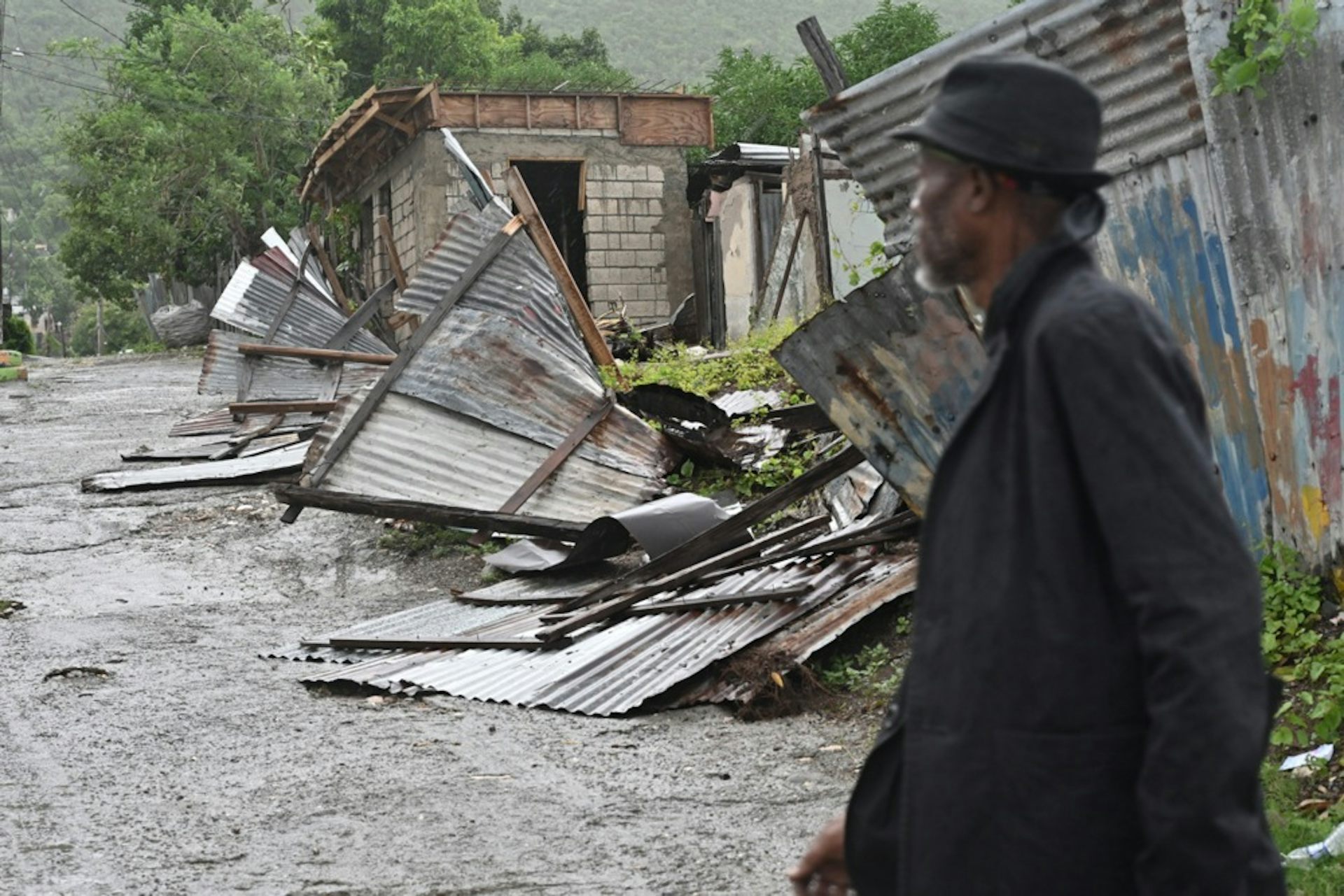 Man looks at damaged buildings in Jamaica