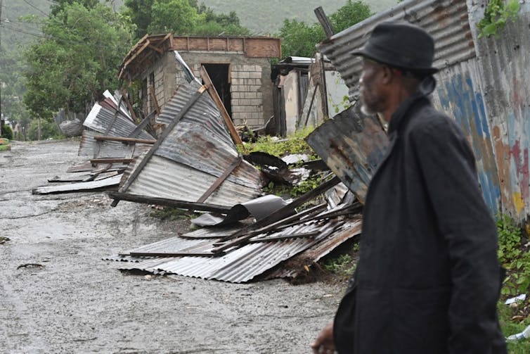 Typhoon Melissa is a caution – why violent storms are increasingly more catching the sector off guard 1 Man looks at damaged buildings in Jamaica