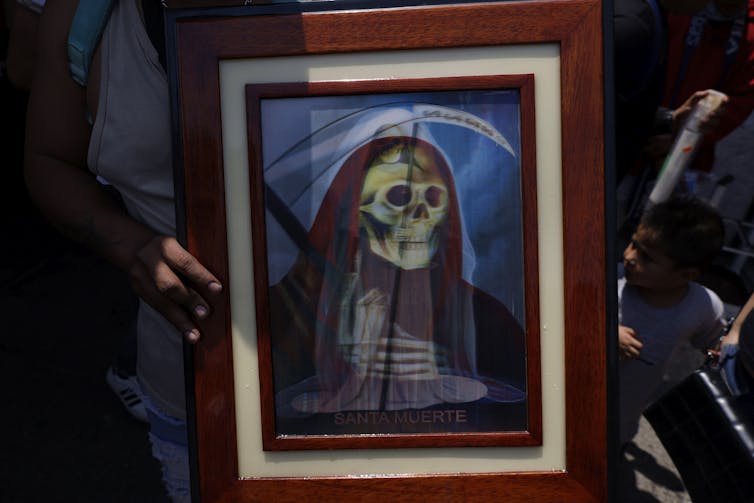 A person holding a picture of a religious icon.