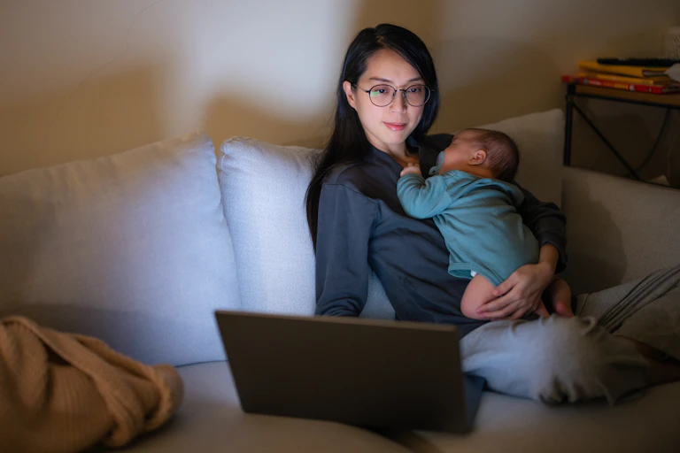 Mother with baby on laptop at night