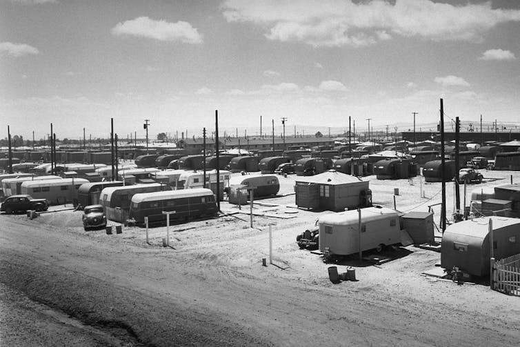 Black and white photo of mobile homes situated in a desert landscape.
