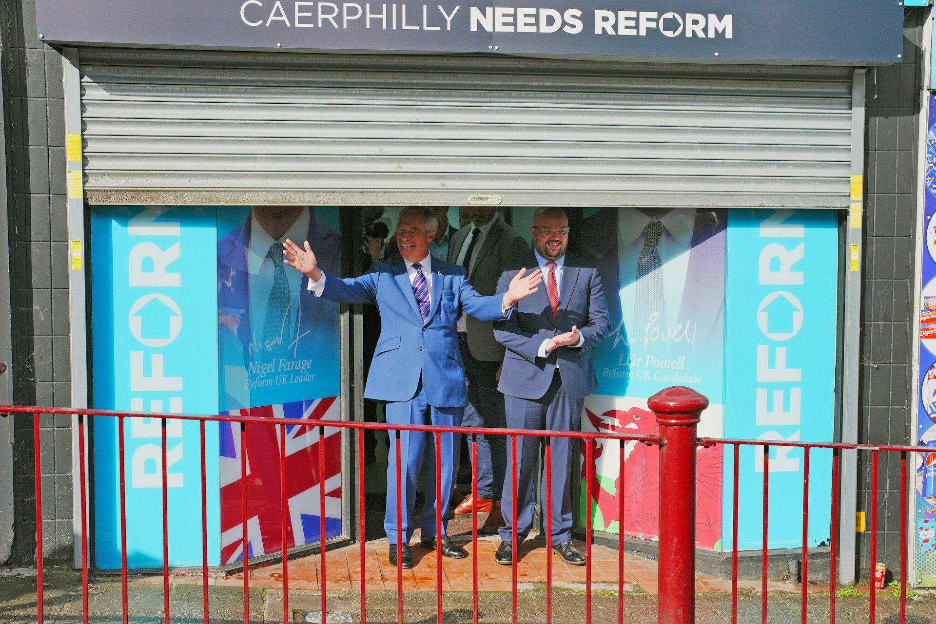 Nigel Farage and Llyr Powell posing in front of their Caerphilly campaign office. 