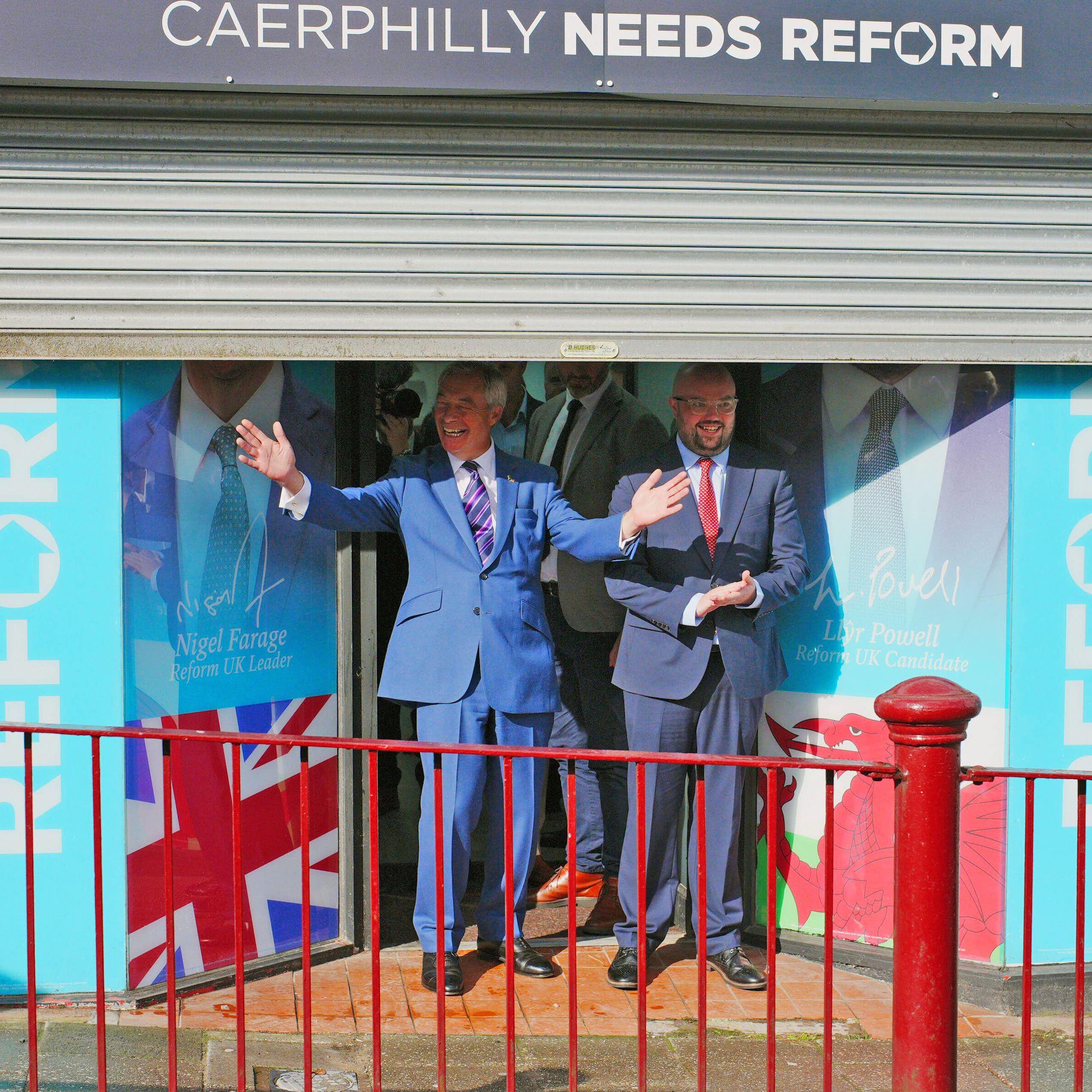 Nigel Farage and Llyr Powell posing in front of their Caerphilly campaign office.