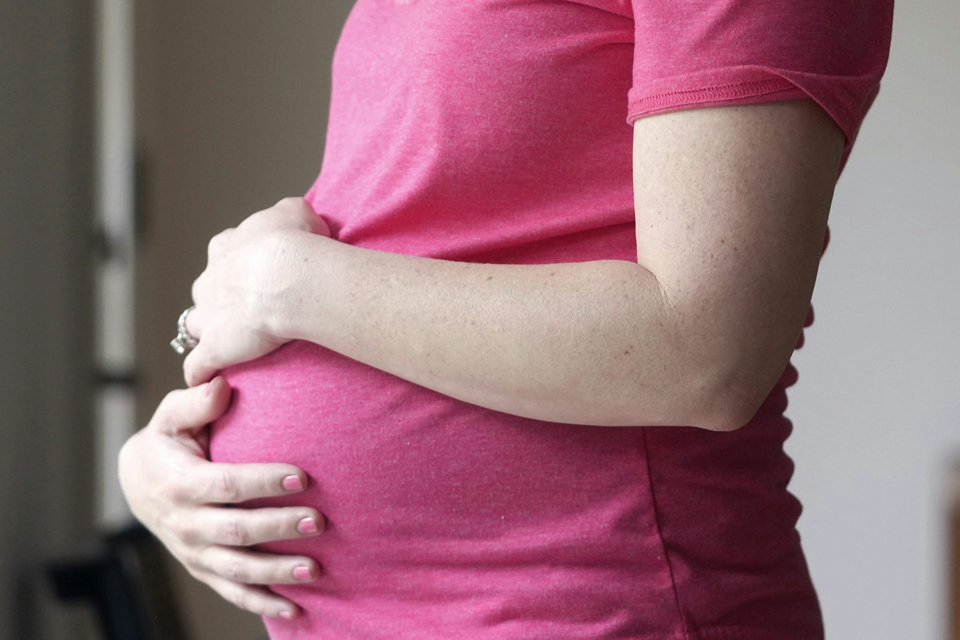 A pregnant woman is holding her belly