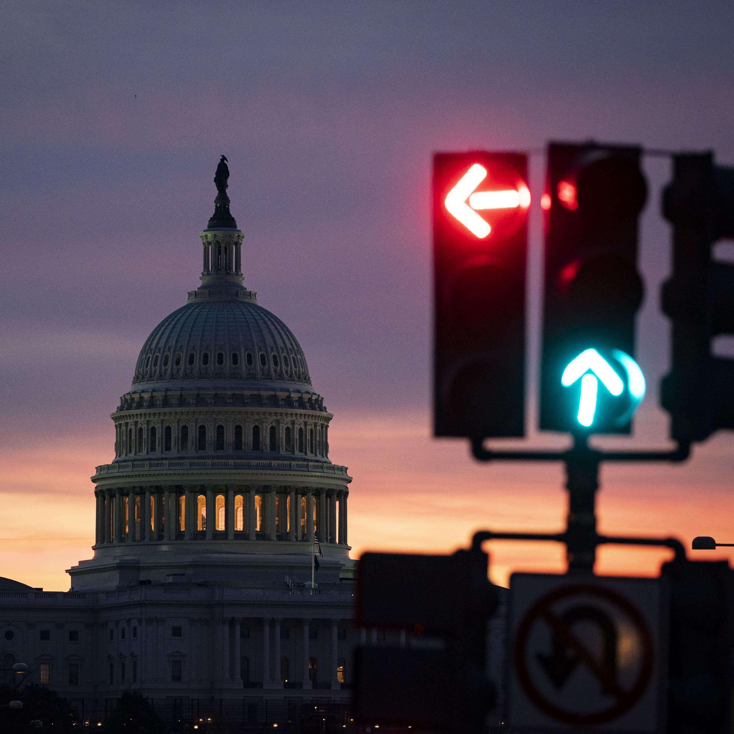 The US Capitol dome in the background with a traffic light signaling red on left, green on go straight.