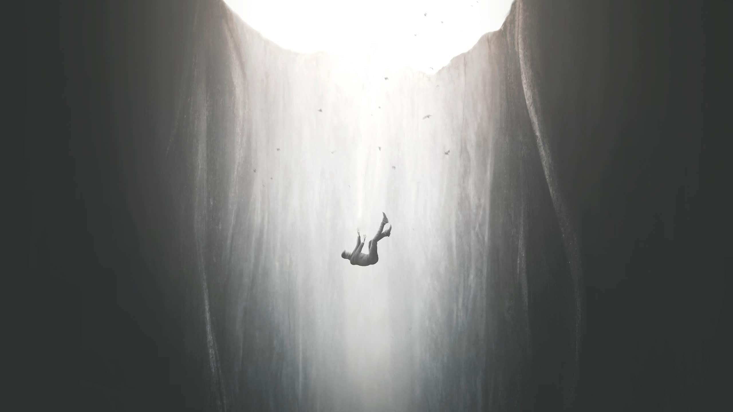 black and white image of a man falling into a bottomless pit