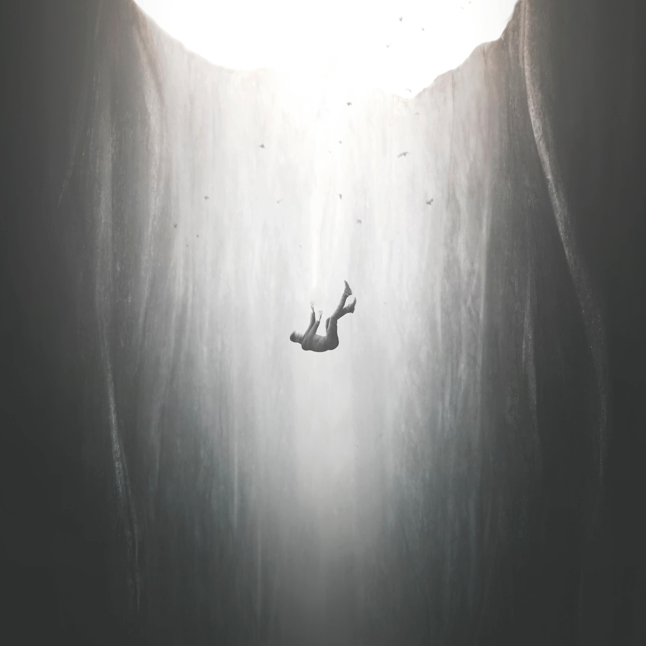 black and white image of a man falling into a bottomless pit