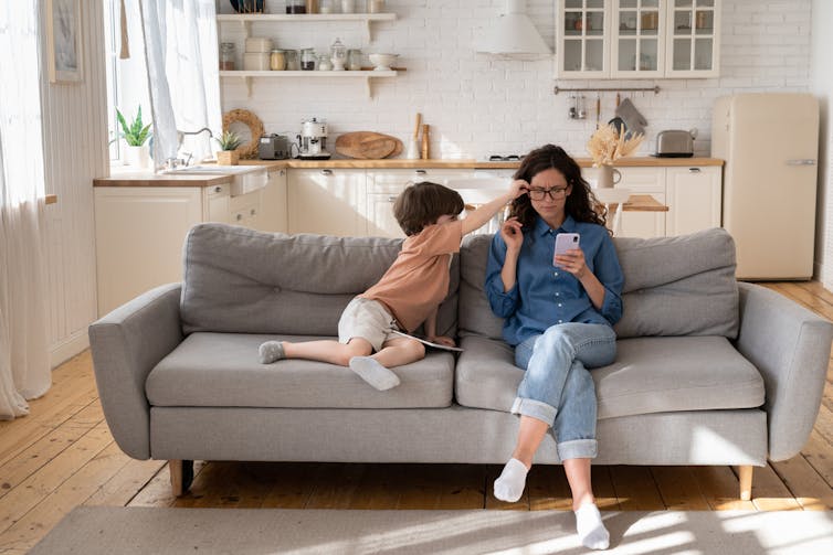 Kid trying to get his mum's attention when she's on her phone