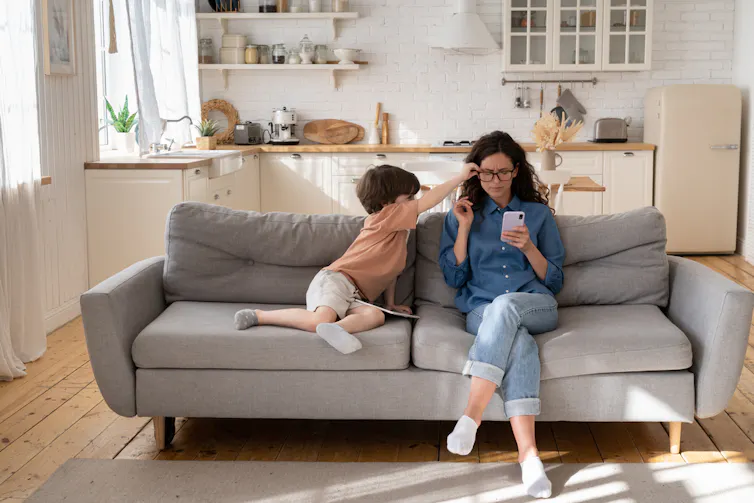 Kid trying to get his mum's attention when she's on her phone