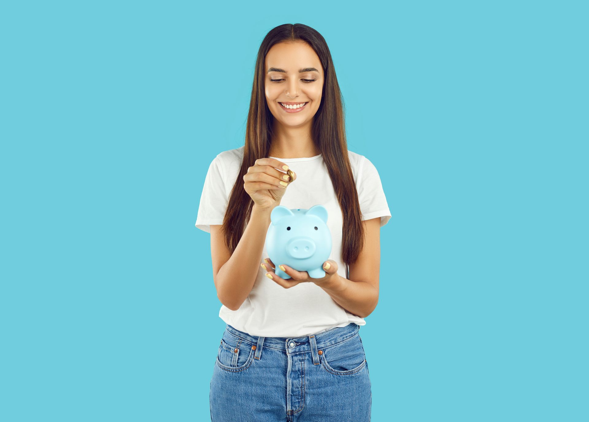 blue background, woman smiling putting coin into blue piggy bank