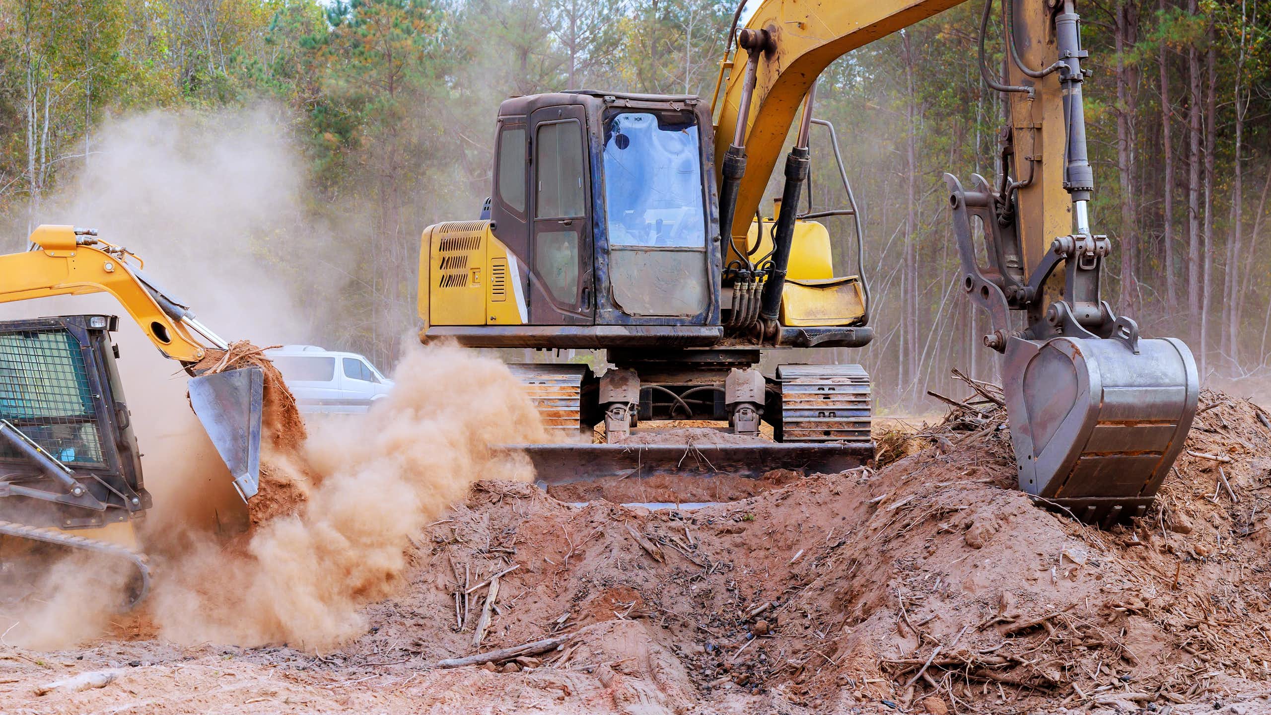 yellow bulldozers excavating soil
