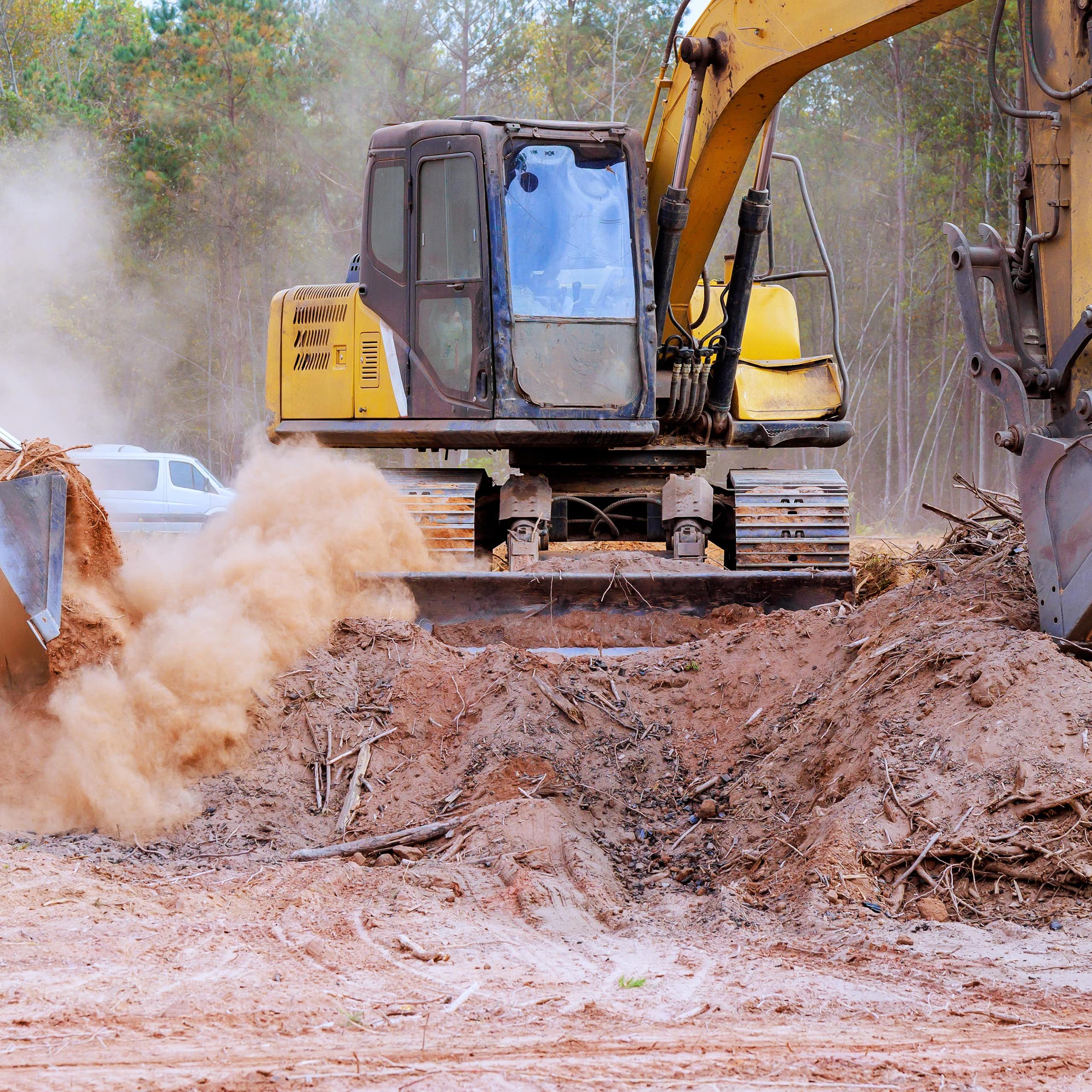 yellow bulldozers excavating soil