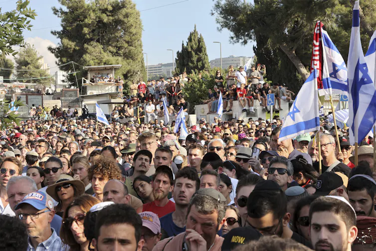 Hundreds of mourners attend a funeral.
