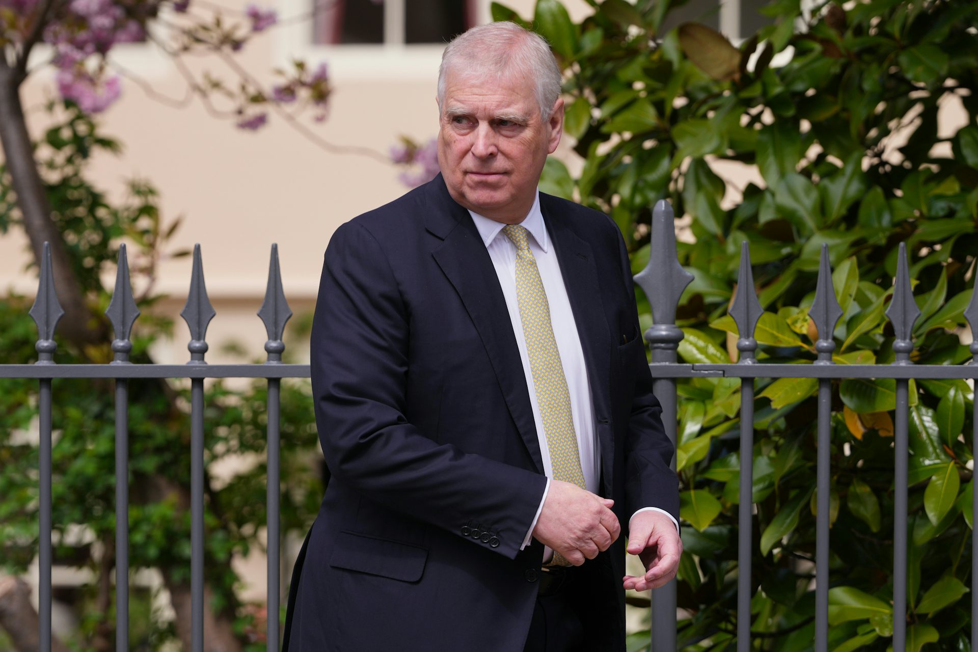 Prince Andrew walks in a street.