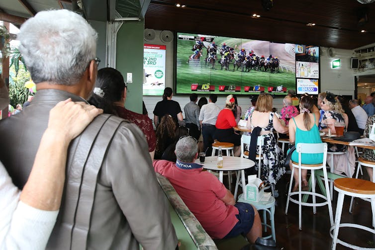 A crowd watches the 2021 Melbourne Cup from a pub in Brisbane.