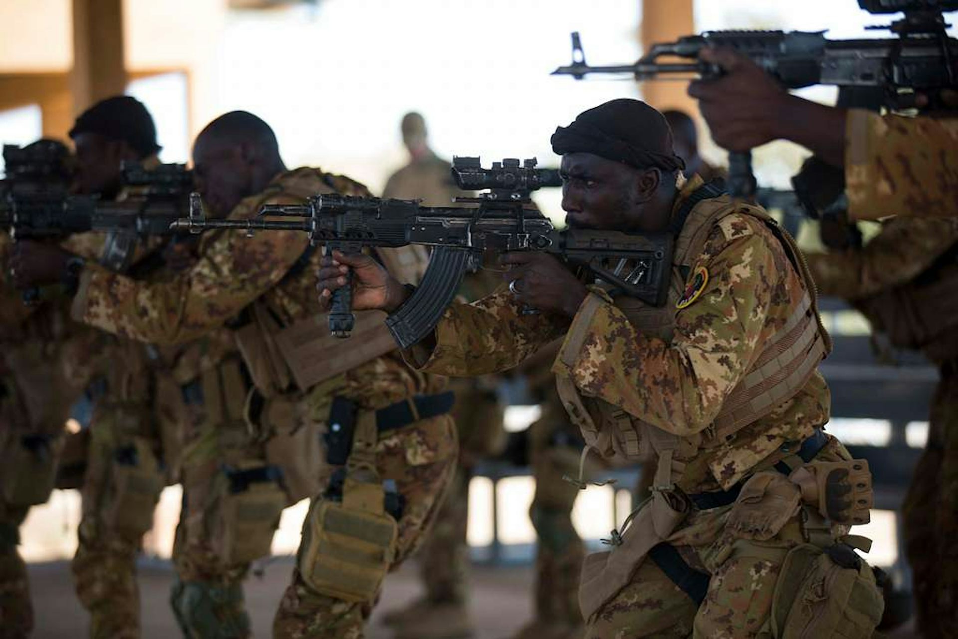 Men in uniform pointing their rifles