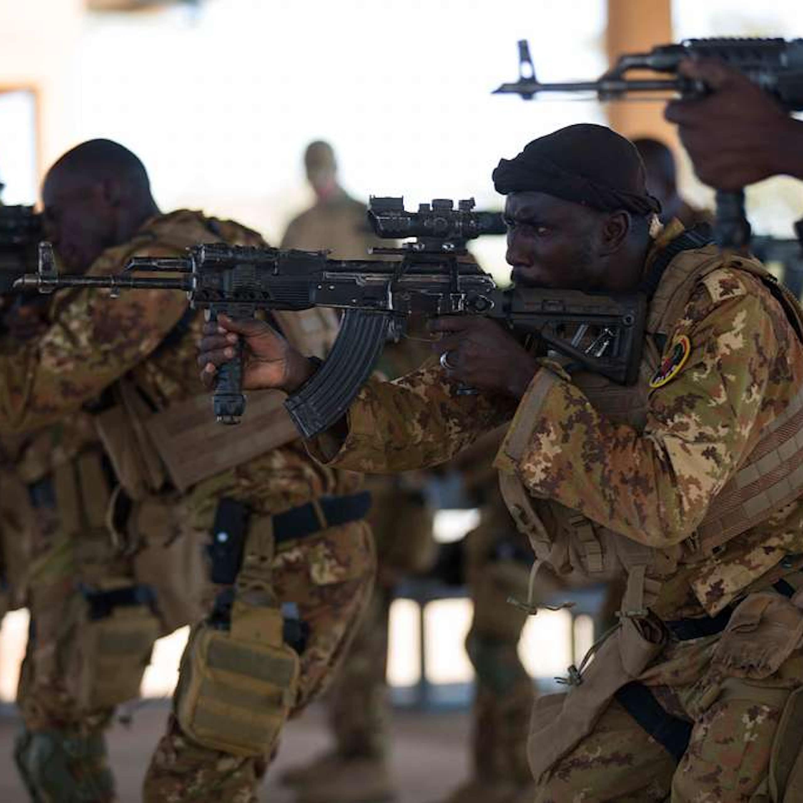 Men in uniform pointing their rifles