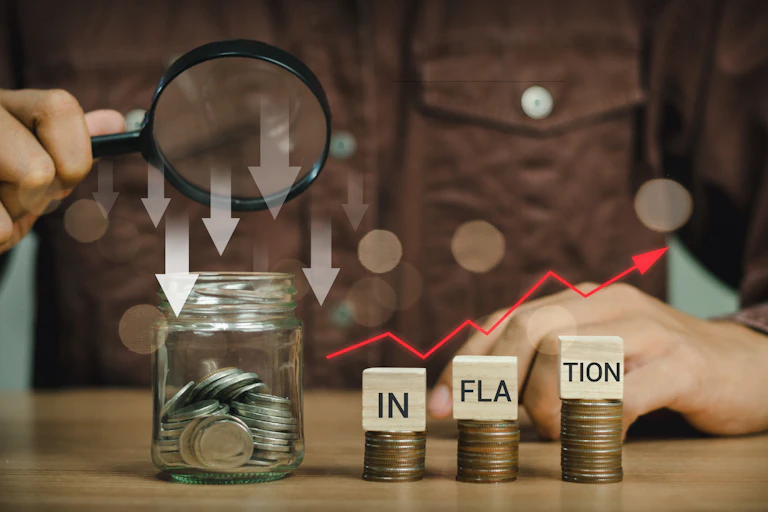 Une personne observe à la loupe le mot inflation.