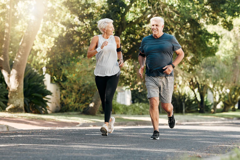 A middle-aged woman and men run through a park together.