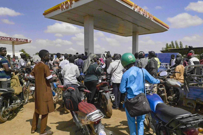 People in Mali queue with their motorcycles at a gas station amid a fuel shortage.