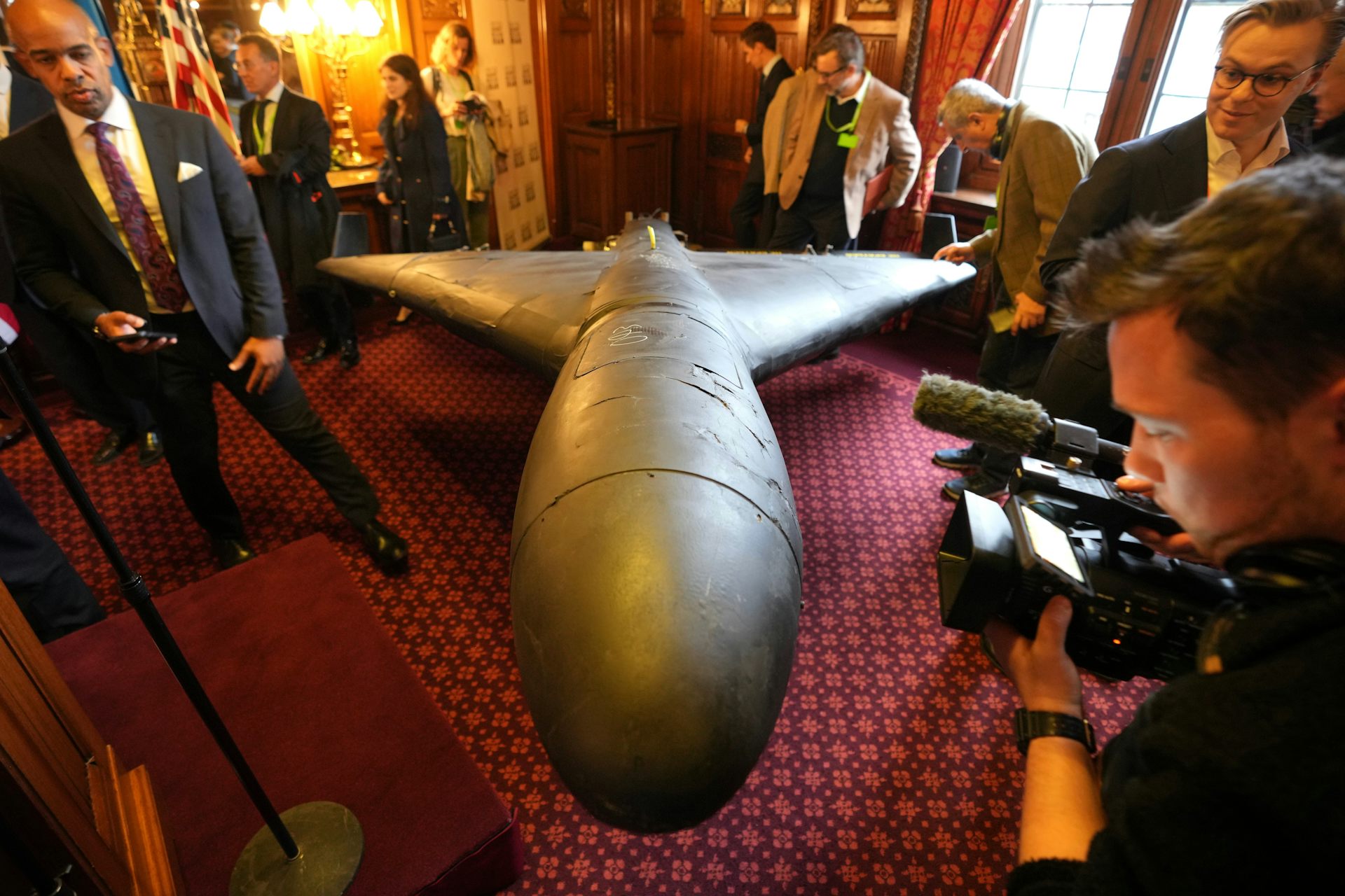 Group of people examining a missile on display in a room