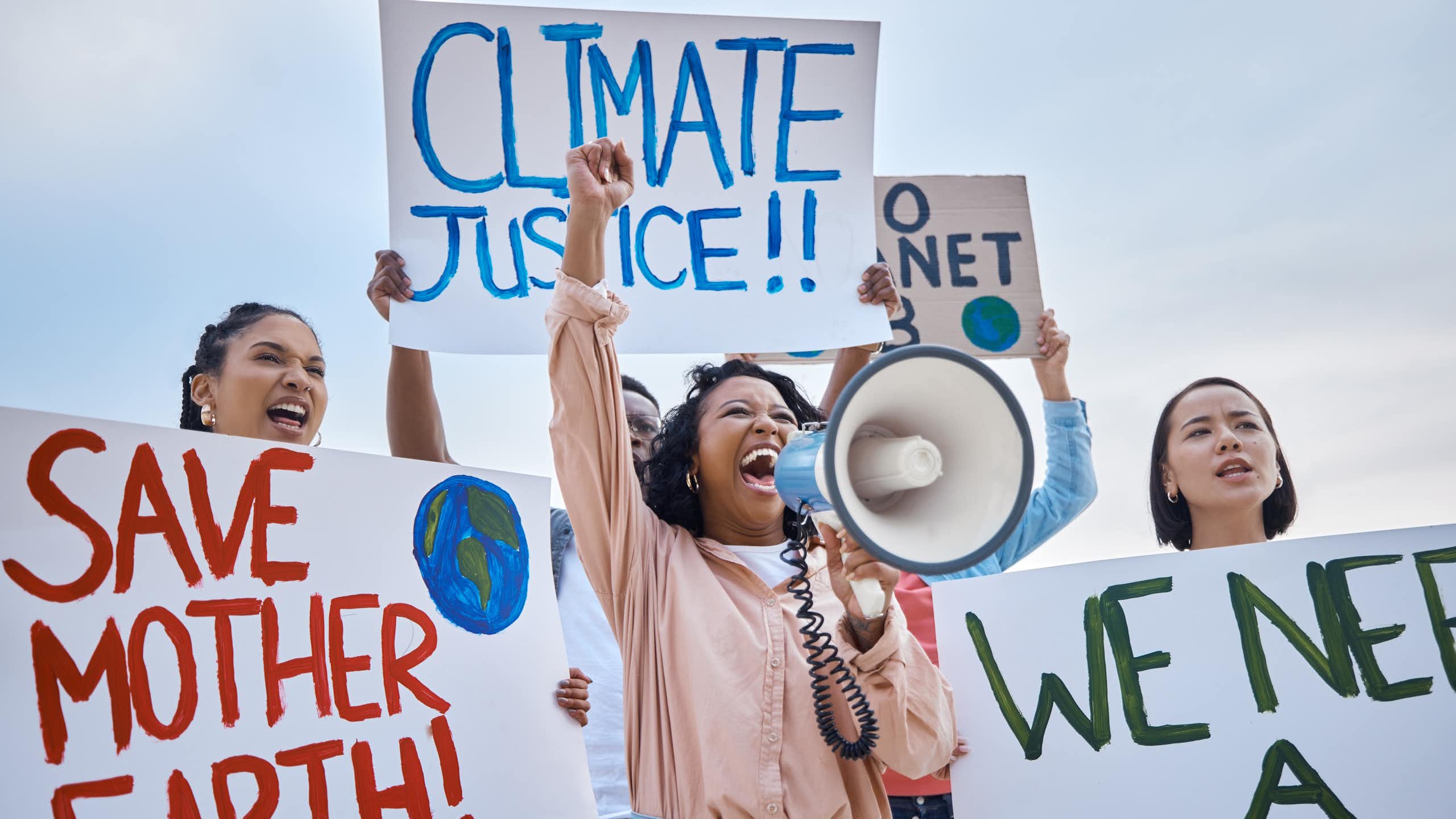 climate protestors shouting with signs calling for climate justice