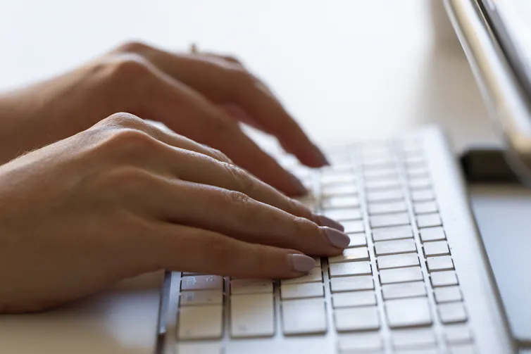 Hands seen at a keyboard.