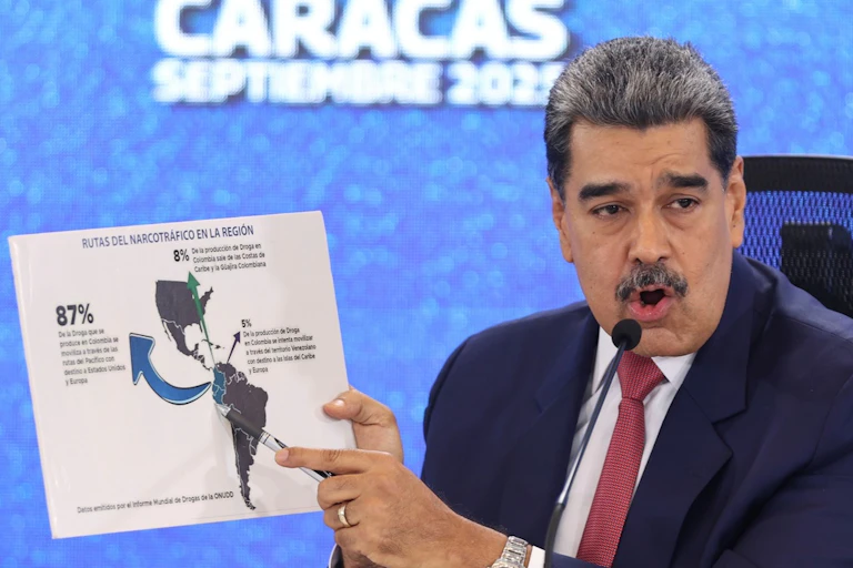 A man points to a map of the Americas.