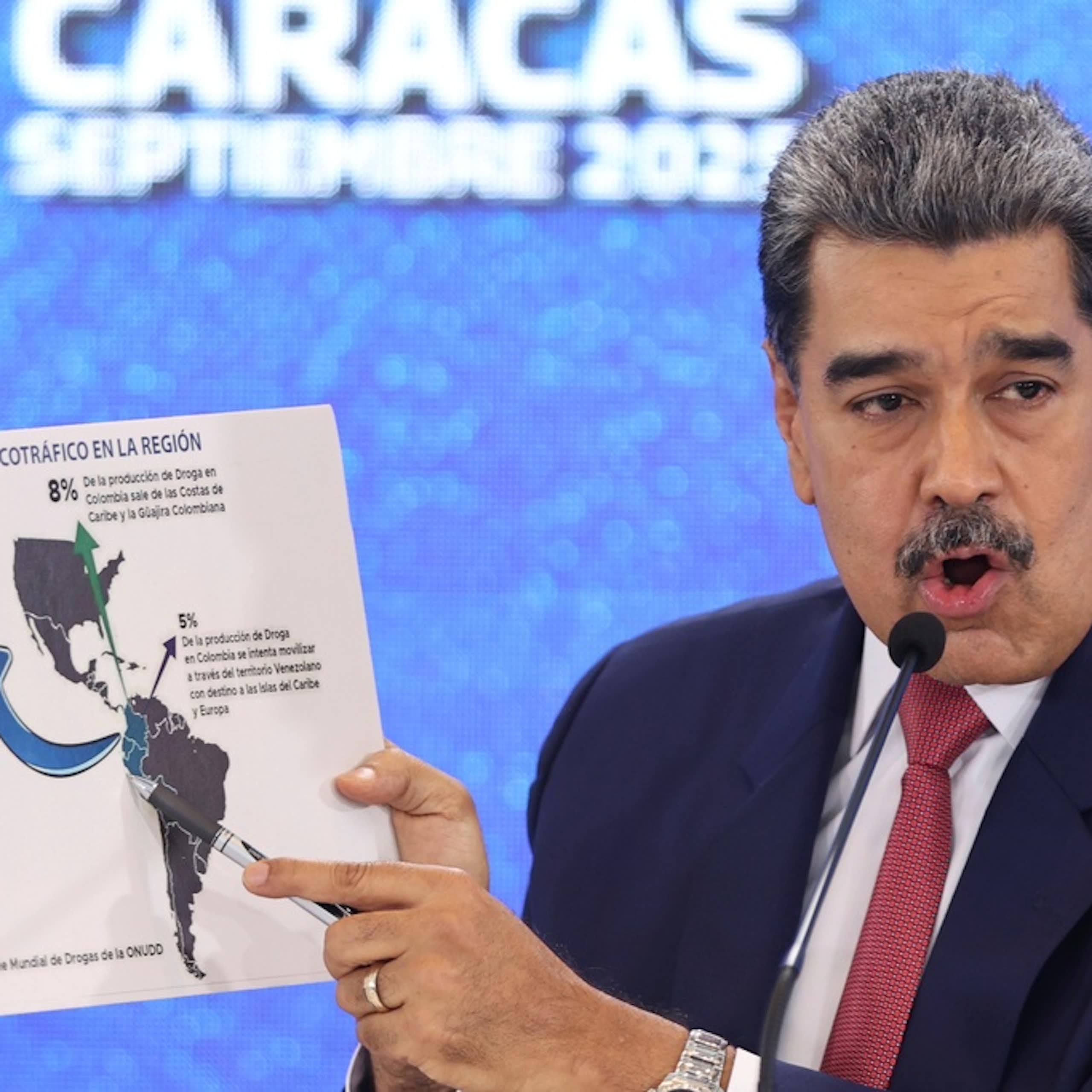 A man points to a map of the Americas.