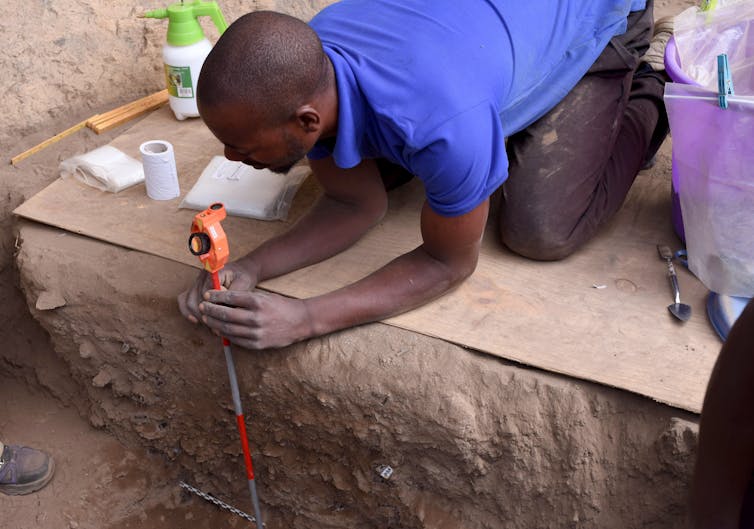 Oldest recognized cremation in Africa poses 9,500-year-old thriller about Stone Age hunter-gatherers 2 man kneeling on a board measures down into the excavated area