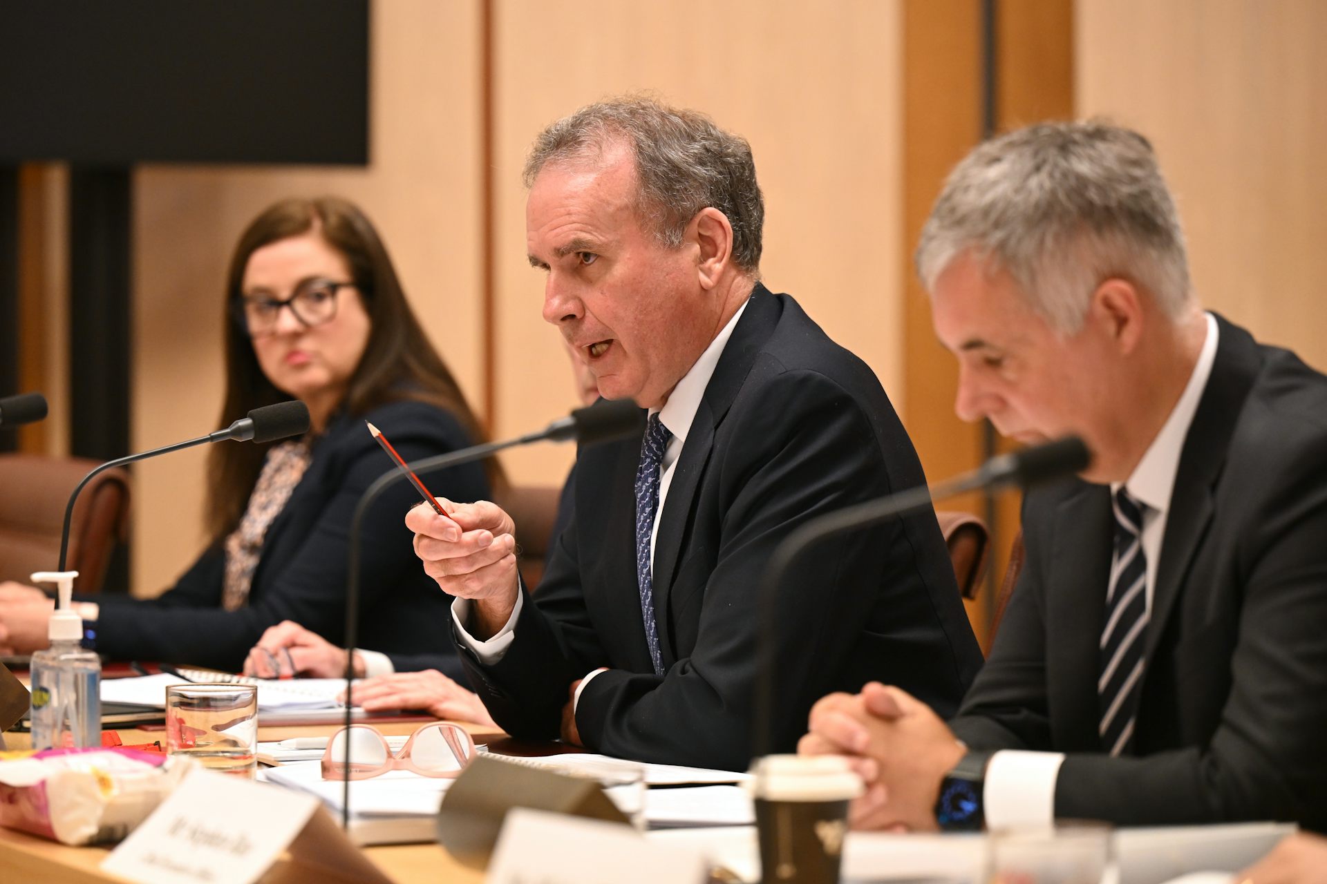 A man in a suit answering a question at a public hearing at Parliament House in Canberra.