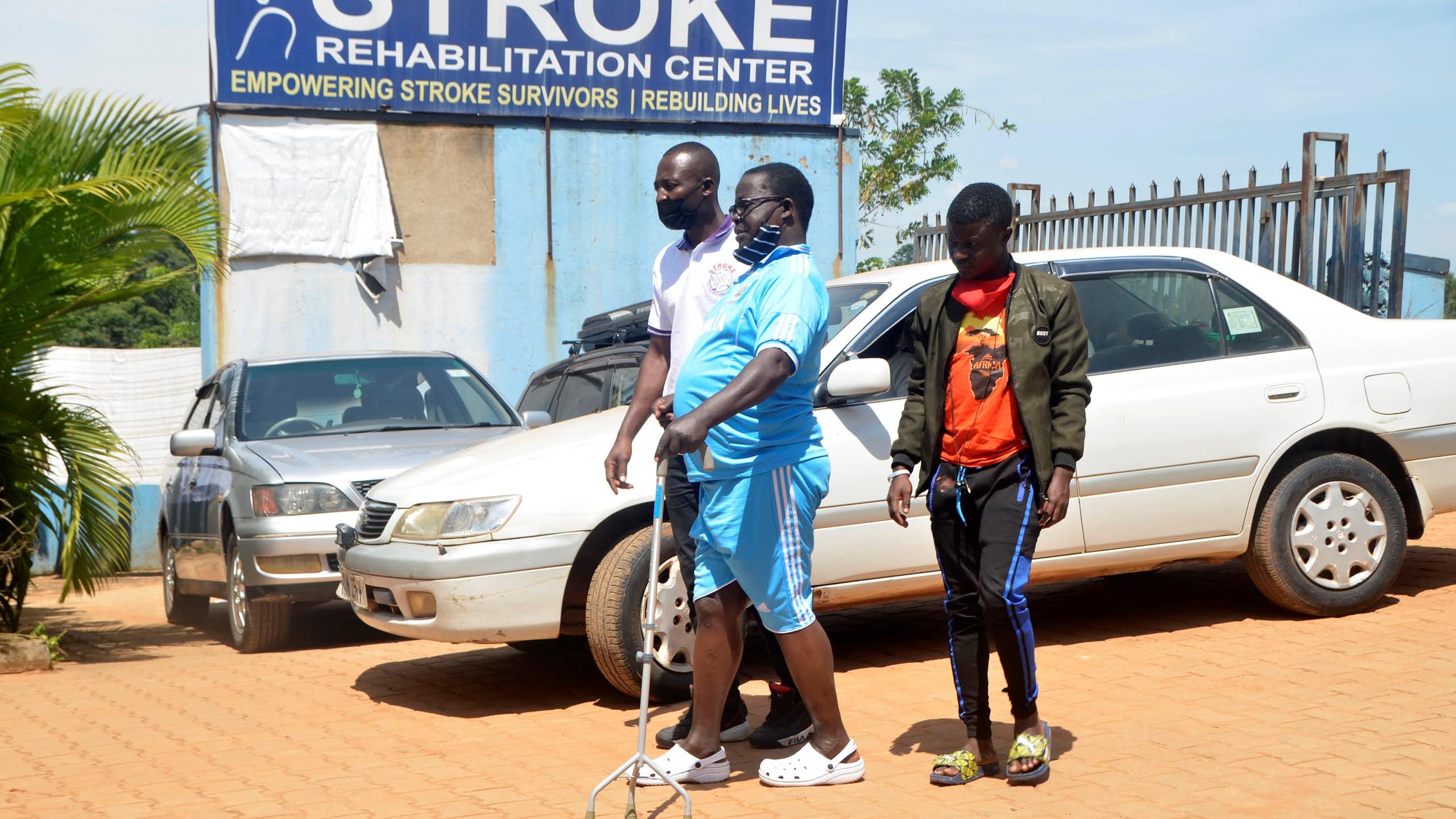 Two men helping a man to walk