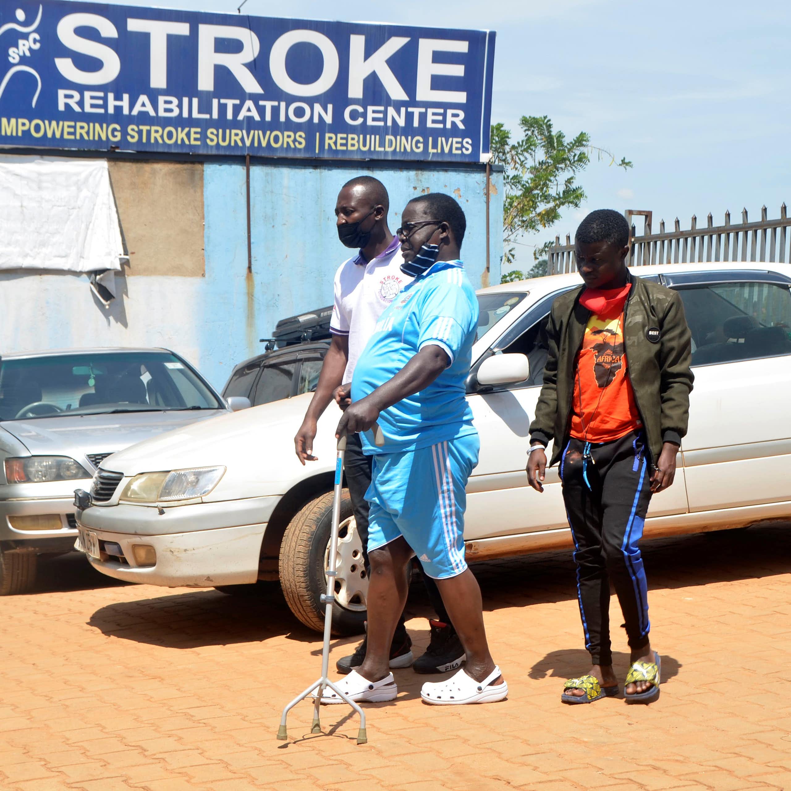 Two men helping a man to walk