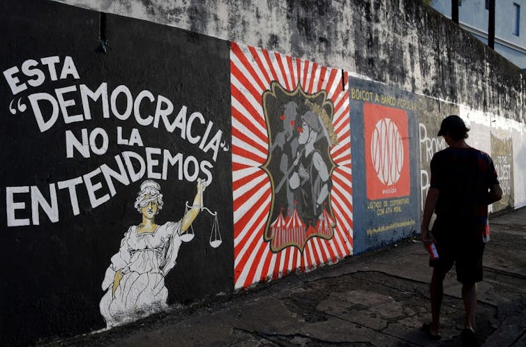 Dangerous Bunny and Puerto Rican Muslims: How each remix what it approach to be Boricua 1 A man walks past a wall with several different political murals painted on it.