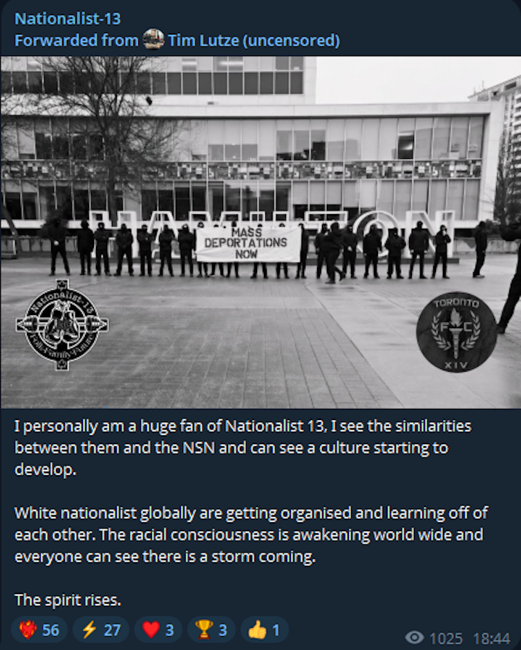 Des hommes alignés tiennent une banderole